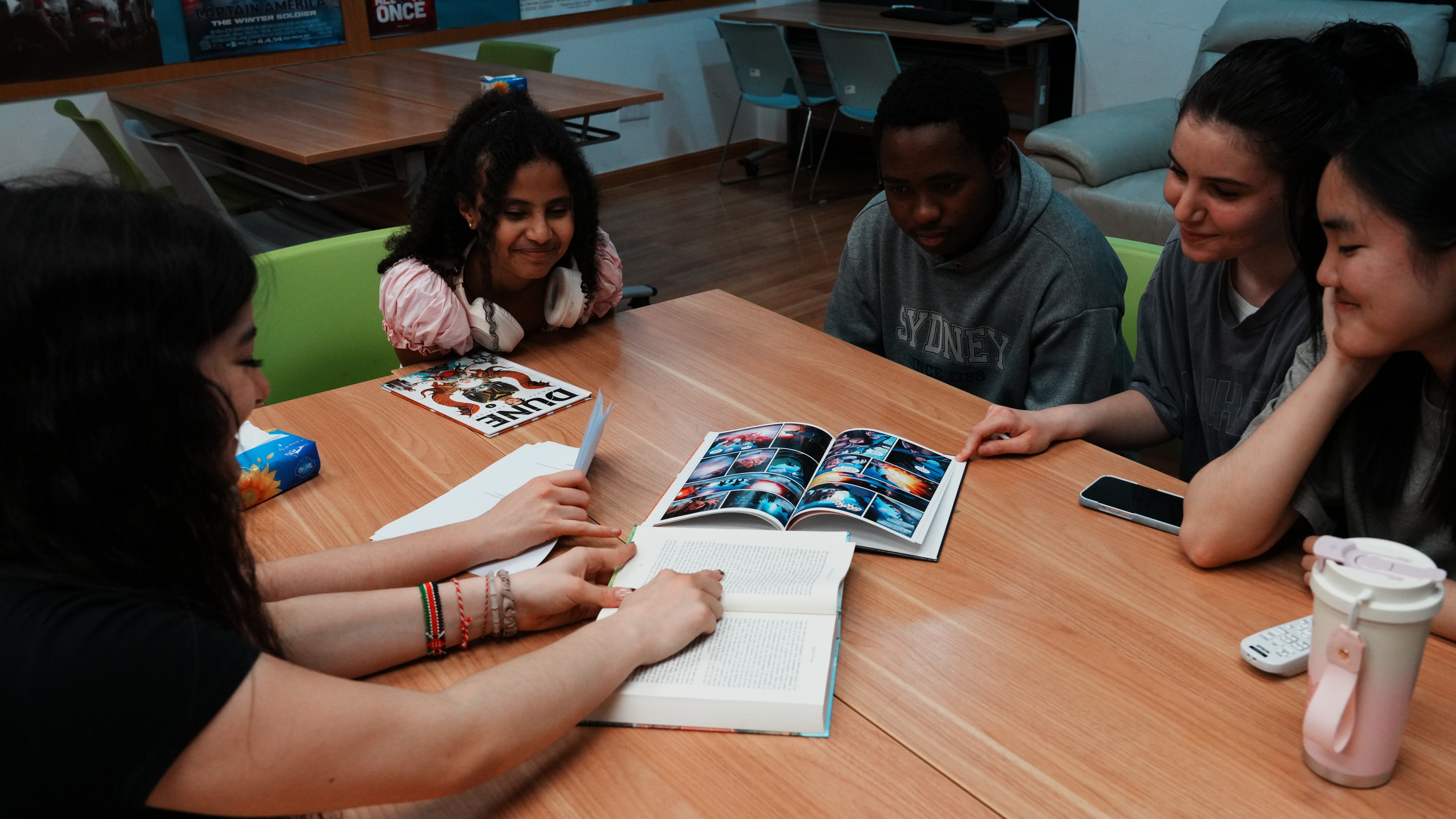 Students reading and talking around a table